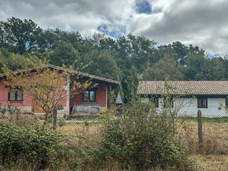 A la izquierda, la casa que se declaró ilegal. A la derecha, de color blanco, y en la misma parcela, una construcción con antena y chimenea. | FOTO: Xosé Lois Colmenero.