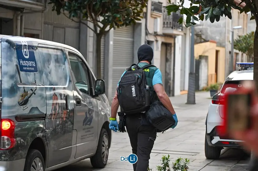 Un agente de la Guardia Civil, saliendo del garaje registrado. | FOTO: Noelia Caseiro.